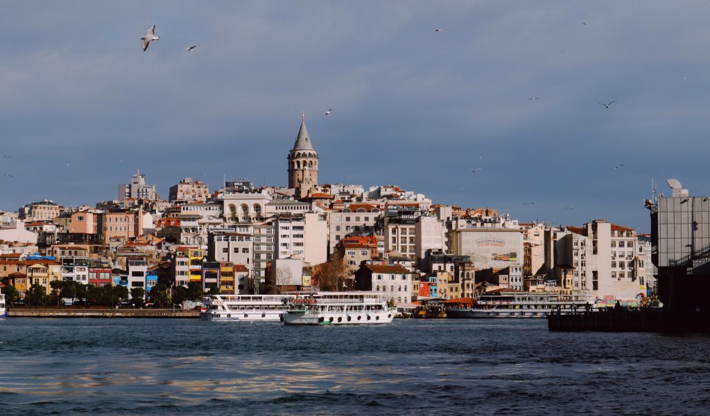 Galata Tower and boats under a clear sky in Istanbul, Turkey.