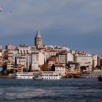 Galata Tower and boats under a clear sky in Istanbul, Turkey.