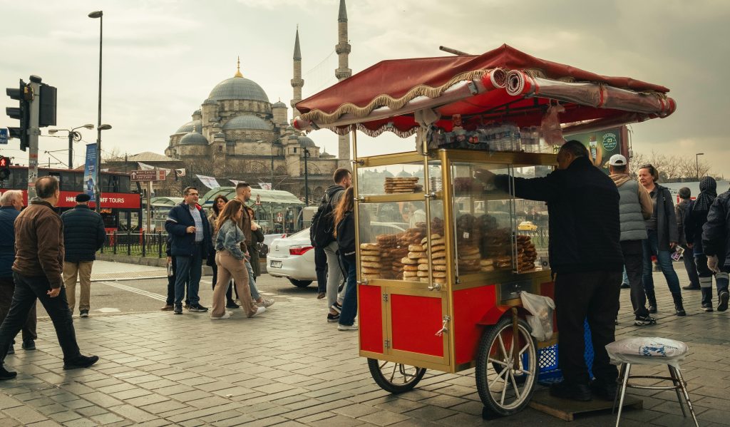 Street food vendor cart in Istanbul with mosque in background, showcasing local culture.