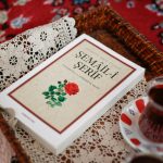 A cozy arrangement featuring Turkish tea and a classical book in a decorative setting.