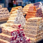 A vibrant assortment of Turkish delight candies stacked in a market display, showcasing variety and color.