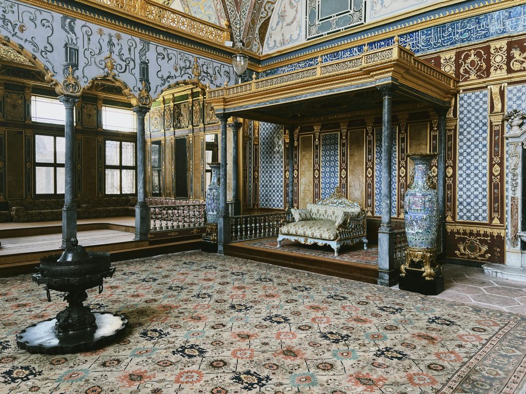 Elegant interior of Topkapi Palace showcasing Ottoman architecture with intricate decor and vibrant pattern details.