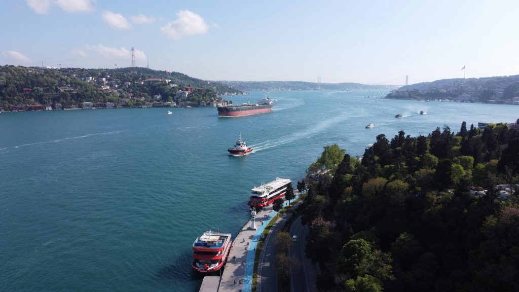 Stunning aerial view of the Bosphorus in İstanbul with boats and the iconic bridge on a sunny day.