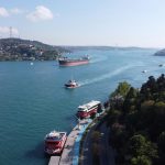 Stunning aerial view of the Bosphorus in İstanbul with boats and the iconic bridge on a sunny day.