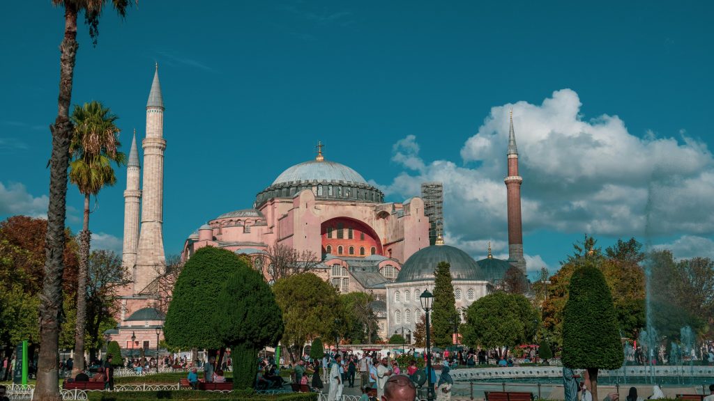 Beautiful view of Hagia Sophia surrounded by lush greenery and blue sky.