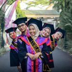 Joyful graduates in caps and gowns celebrating their success outdoors.