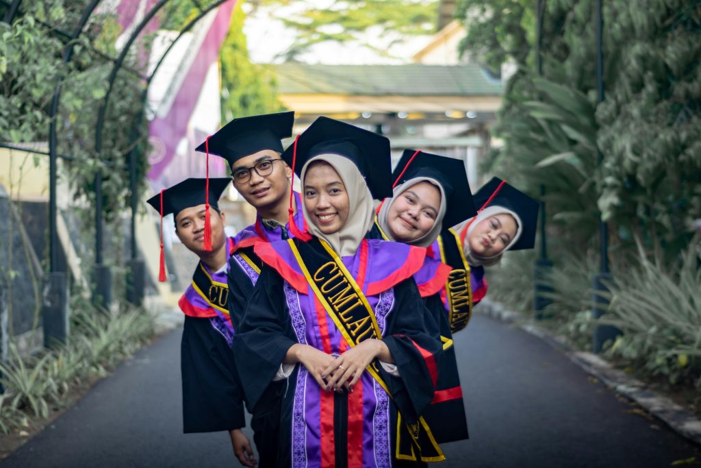 Joyful graduates in caps and gowns celebrating their success outdoors.