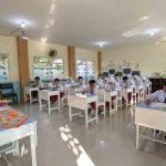 Students in an Indonesian classroom taking an exam under natural lighting.