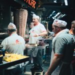 Chefs preparing traditional doner kebab at a busy night street food stall in Istanbul.