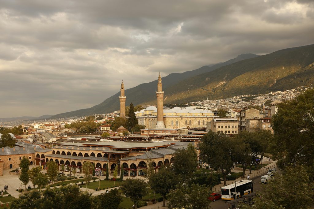 A beautiful aerial view of Bursa, Turkey featuring the historic Ulu Cami Mosque under a dramatic sky.