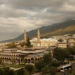 A beautiful aerial view of Bursa, Turkey featuring the historic Ulu Cami Mosque under a dramatic sky.