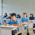 High school students in uniform attentively studying in an Indonesian classroom.