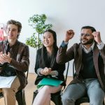A group of diverse entrepreneurs in a workspace celebrating success and motivation.
